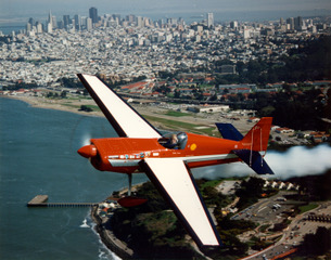 Airplane flying over city and coastline.